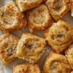 A close-up of golden-brown Parmesan garlic pizza rolls, baked to perfection with melted cheese, herbs, and a crispy crust.