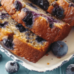 Close-up of slices of blueberry banana bread with visible blueberries and a golden, crisp crust