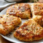 Golden brown Irish potato cakes (potato farls) served on a white plate, garnished with fresh herbs.