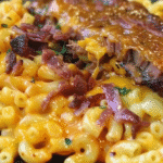 Close-up of golden, crispy Brisket Mac & Cheese Tacos filled with smoky brisket and creamy mac and cheese, garnished.